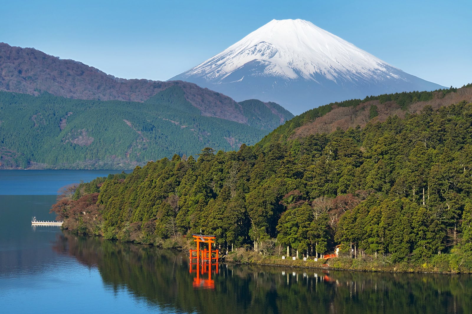 A mountain with a red torii gate in the foreground.